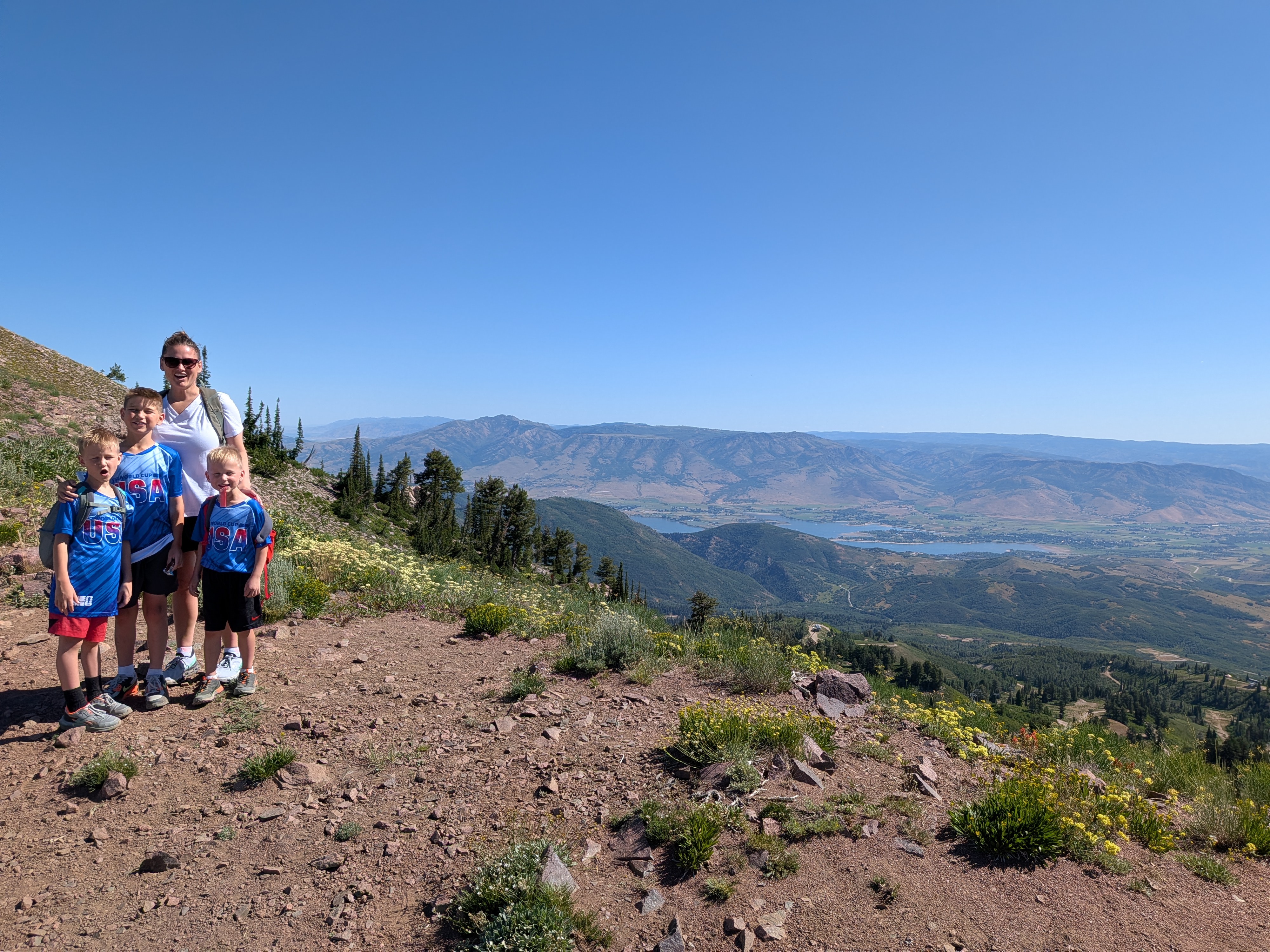 Family standing near the Strawberry Needles high point with mountain and valley views behind them